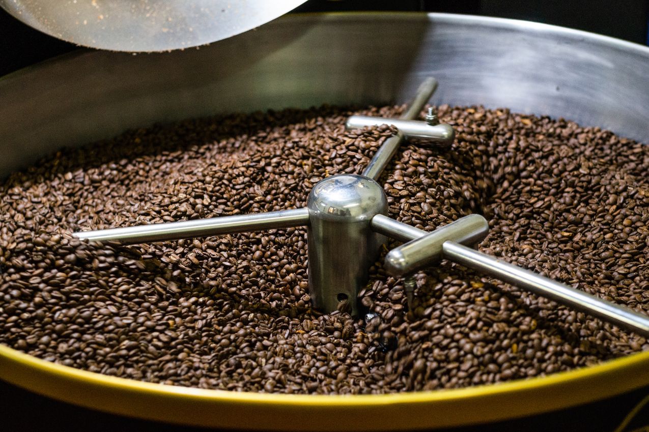 Torréfaction du café : les grains brunissent sous l'effet de la chaleur Torréfaction du café en cours dans un torréfacteur, grains en train de brunir