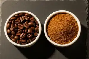 Deux petits bols blancs côte à côte sur ardoise noire, l'un avec des grains de café arabica torréfiés, l'autre avec des granules de café soluble