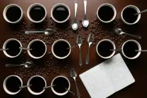 cupping professionnel de café de spécialité, bols blancs et grains sur table en bois sombre