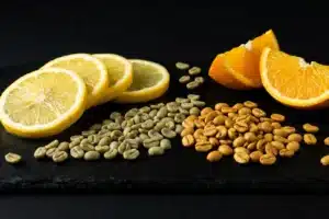 Agrumes tranchés et grains de café sur ardoise noire illustrant l'acidité aromatique du café