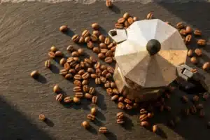 Cafetière italienne vue de dessus sur ardoise avec grains de café pour choisir le bon café moka